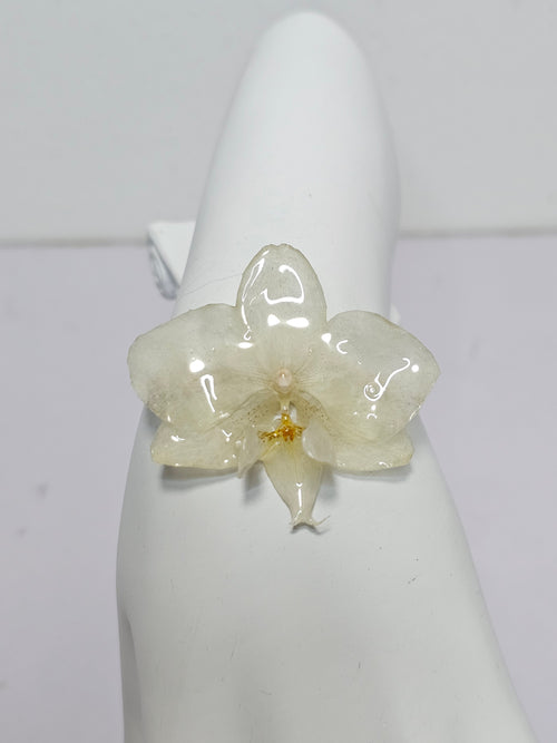 Pulsera de Mini Orquídea Blanca artesanal con flor natural preservada; material: acero inoxidable