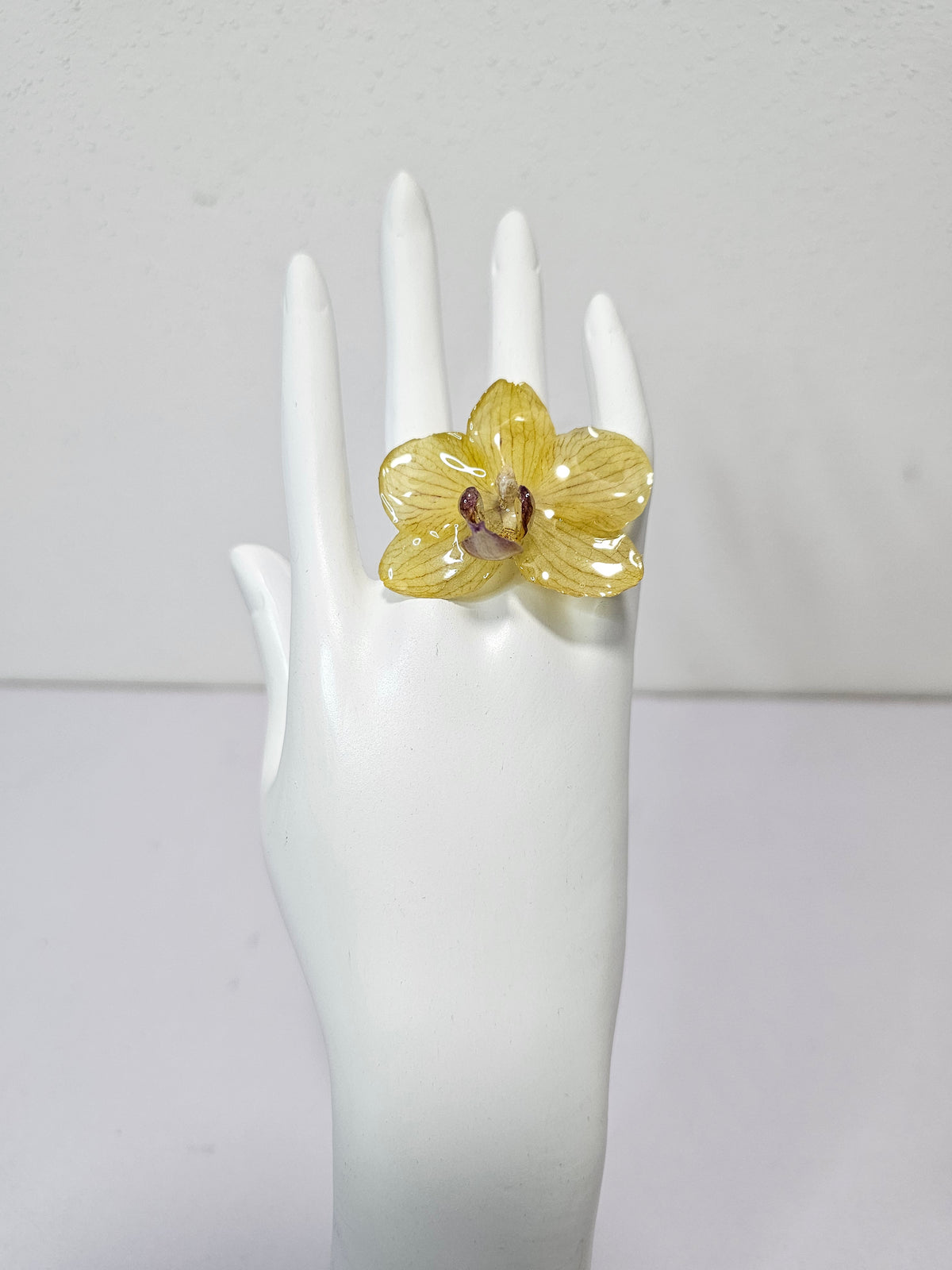 Anillo de Mini Orquídea Amarilla artesanal con flor natural preservada; material: acero inoxidable, vista 2