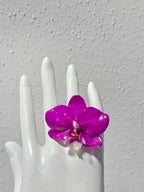 Anillo de Mini Orquídea Magenta artesanal con flor natural preservada; material: acero inoxidable