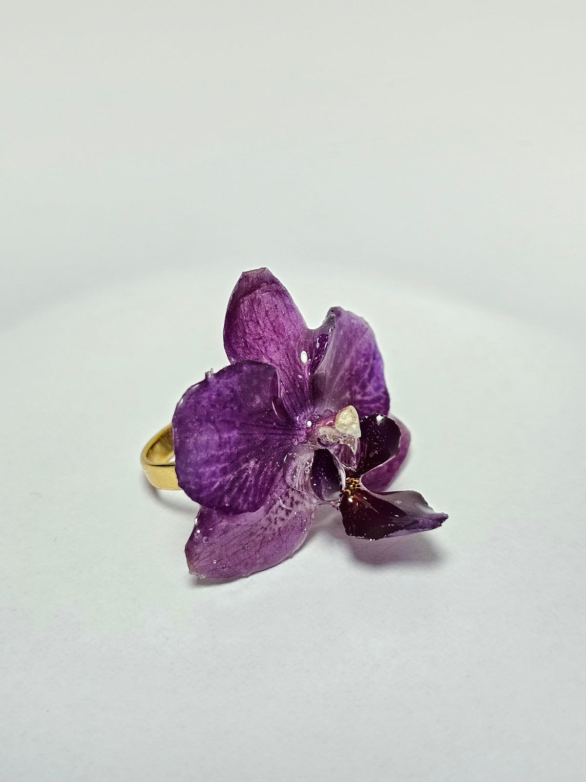 Anillo de Orquídea Morada artesanal con flor natural preservada; material: acero inoxidable, vista 3