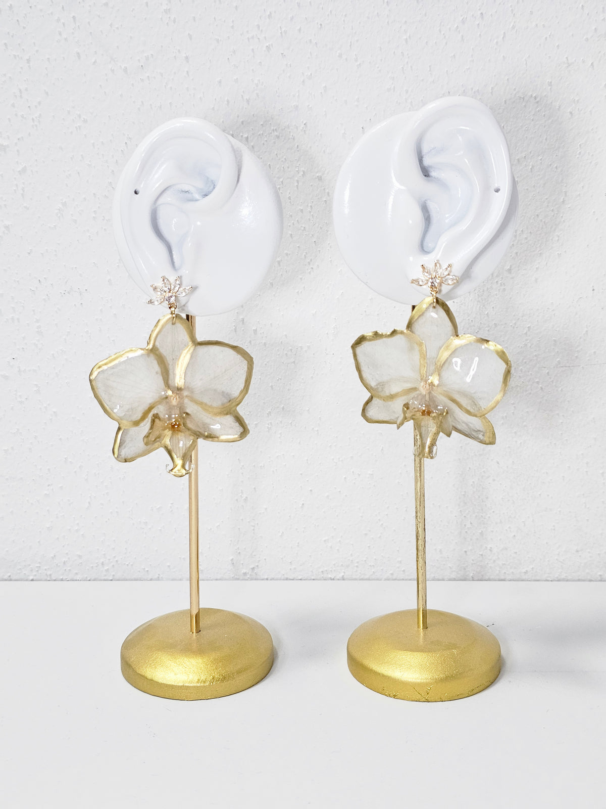 Aretes de Mini Orquídea Blanca Dorada artesanal con flor natural preservada; material: acero inoxidable, vista 3