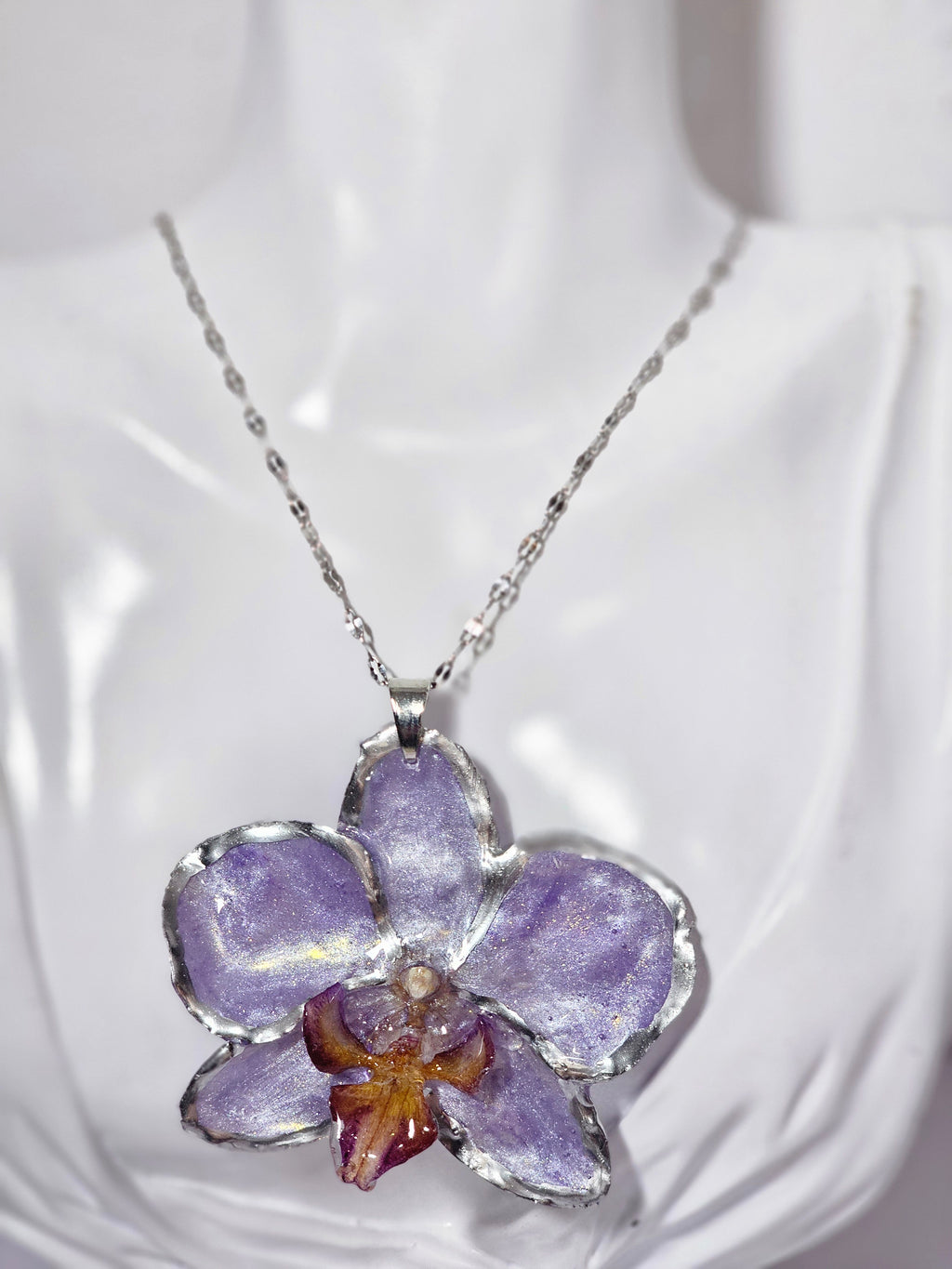 Collar de Orquídea Lila Tornasol artesanal con flor natural preservada; material: acero inoxidable