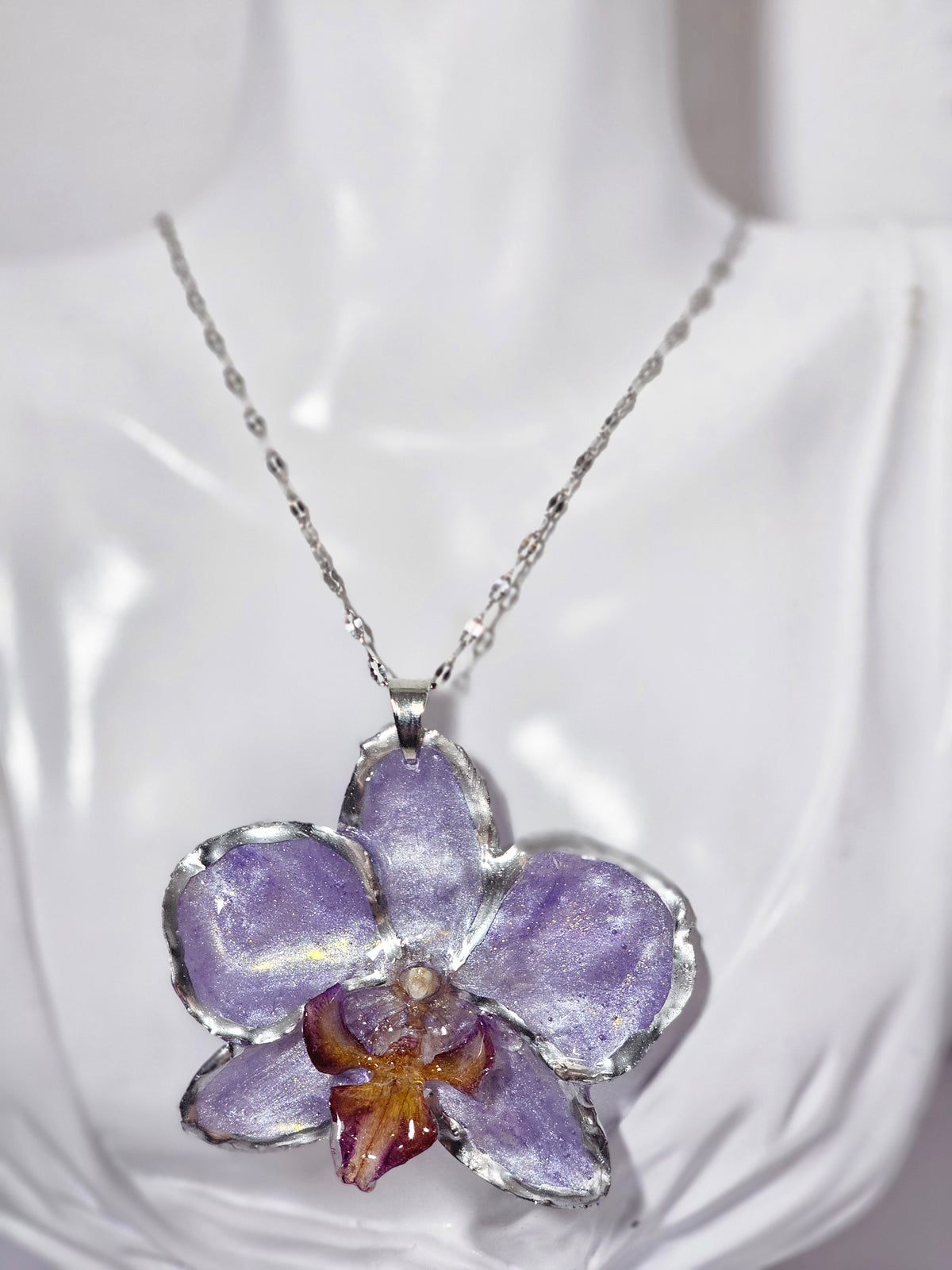 Collar de Orquídea Lila Tornasol artesanal con flor natural preservada; material: acero inoxidable