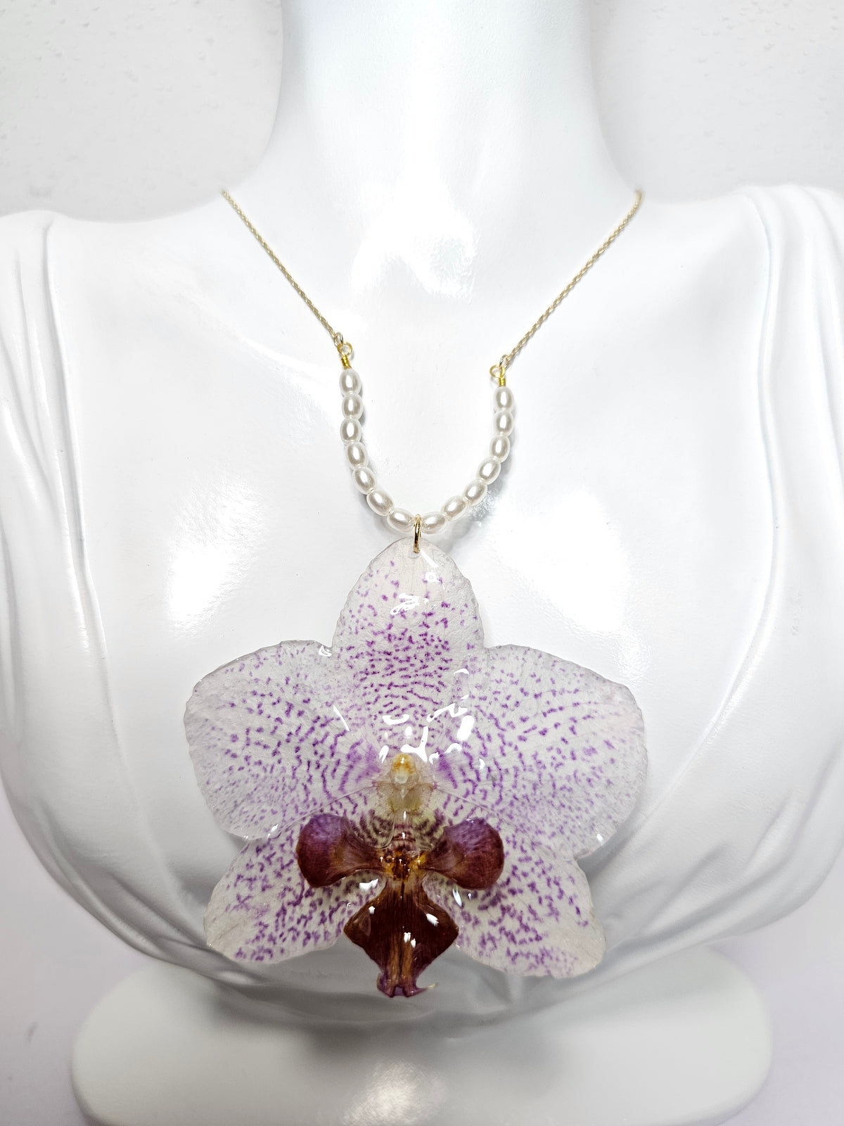 Collar de Orquídea Morada Moteada artesanal con flor natural preservada; material: acero inoxidable