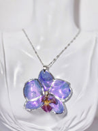 Collar de Orquídea Morada Tornasol artesanal con flor natural preservada; material: acero inoxidable