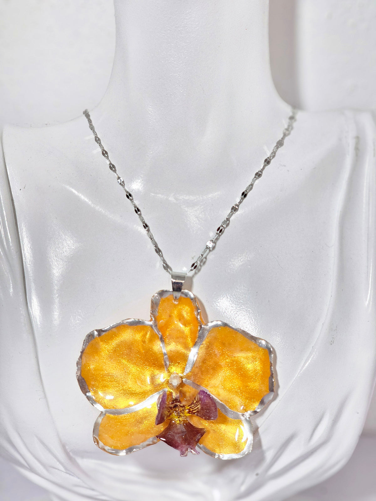 Collar de Orquídea Naranja Tornasol artesanal con flor natural preservada; material: acero inoxidable