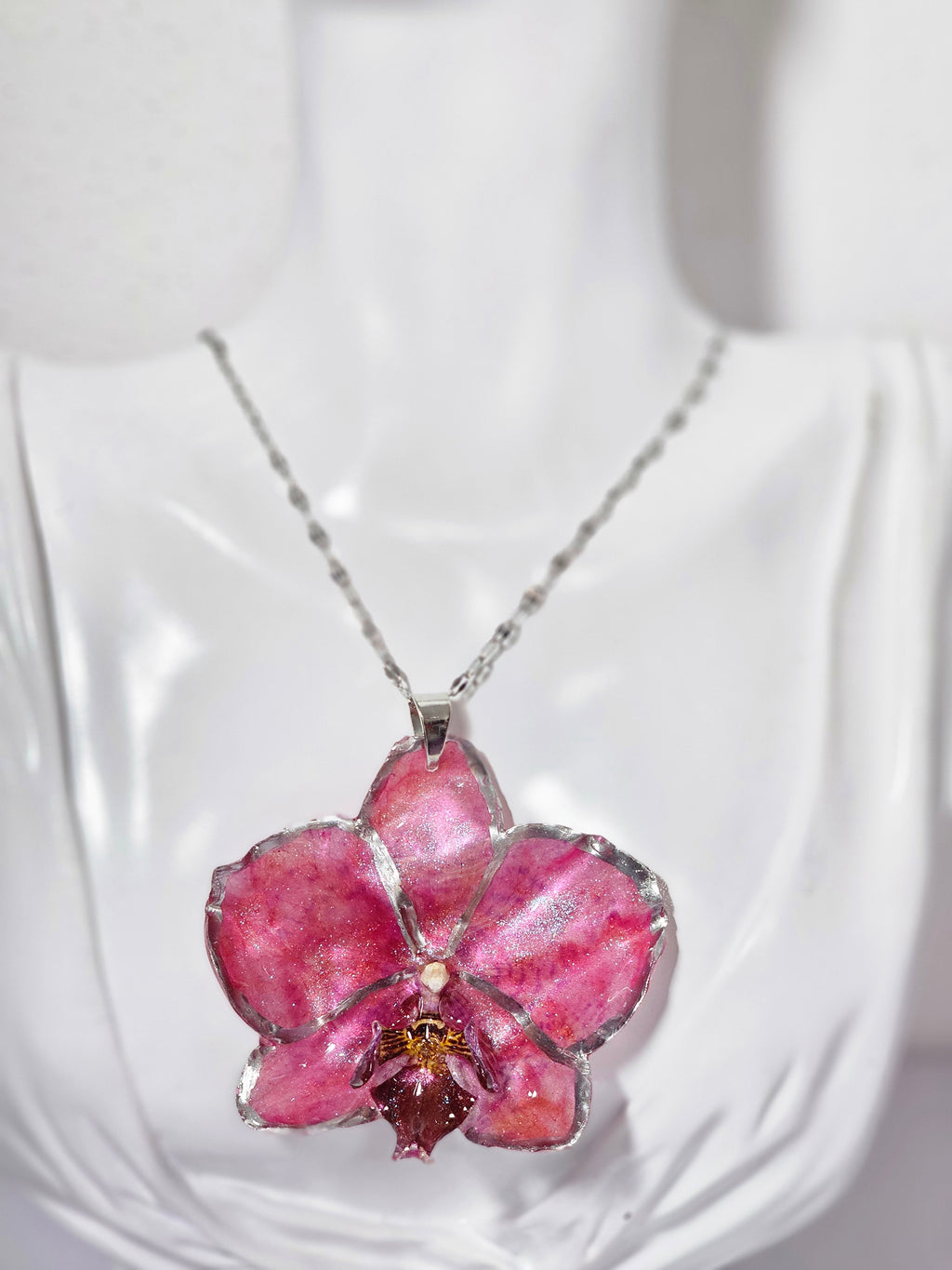 Collar de Orquídea Rosa Tornasol artesanal con flor natural preservada; material: acero inoxidable
