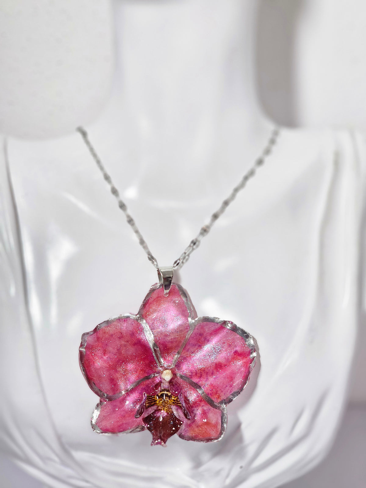 Collar de Orquídea Rosa Tornasol artesanal con flor natural preservada; material: acero inoxidable