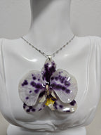 Collar de Orquídea Vaquita artesanal con flor natural preservada; material: acero inoxidable