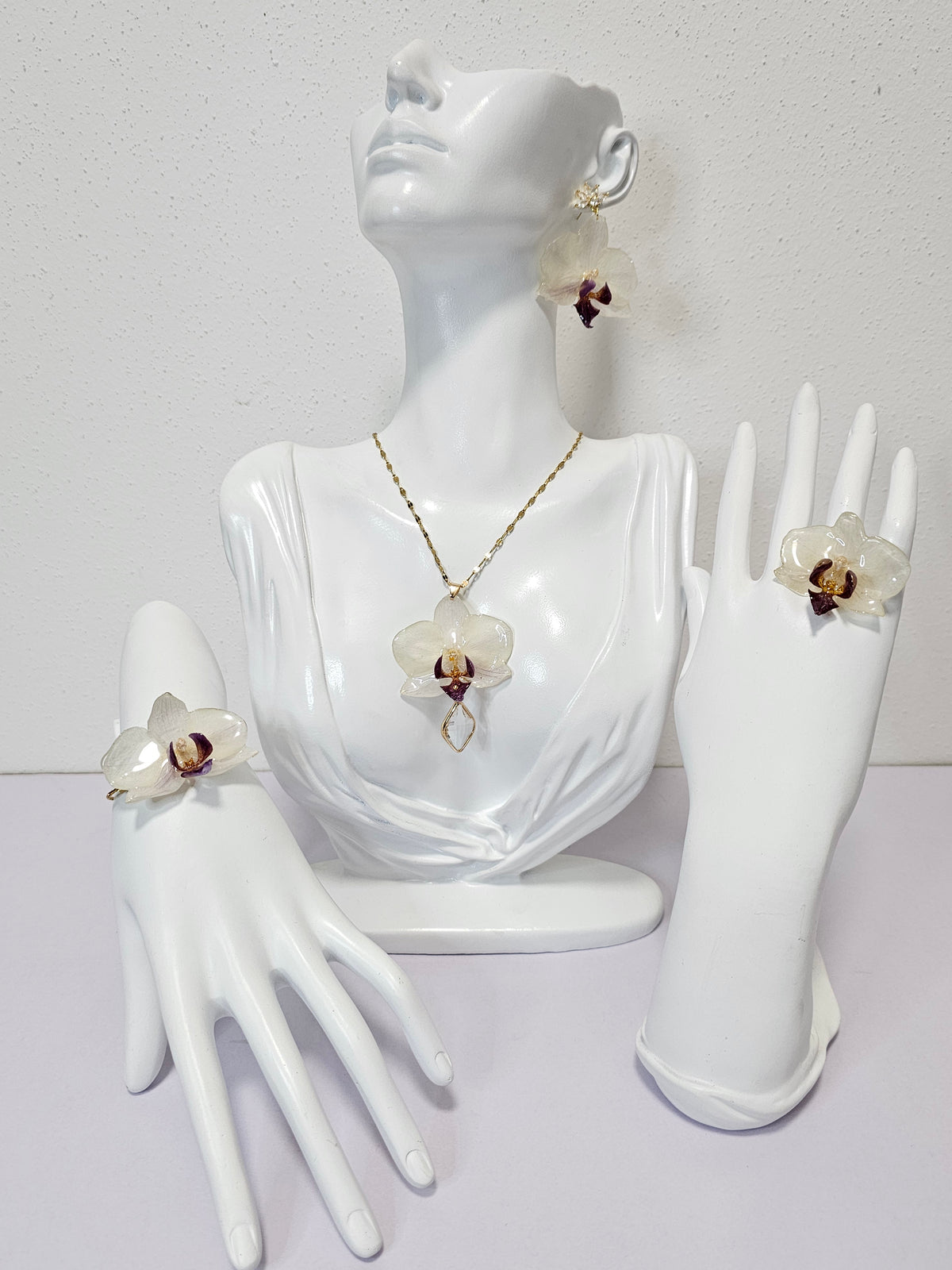 Conjunto de Mini Orquídea Blanca con Morado artesanal con flor natural preservada; material: acero inoxidable