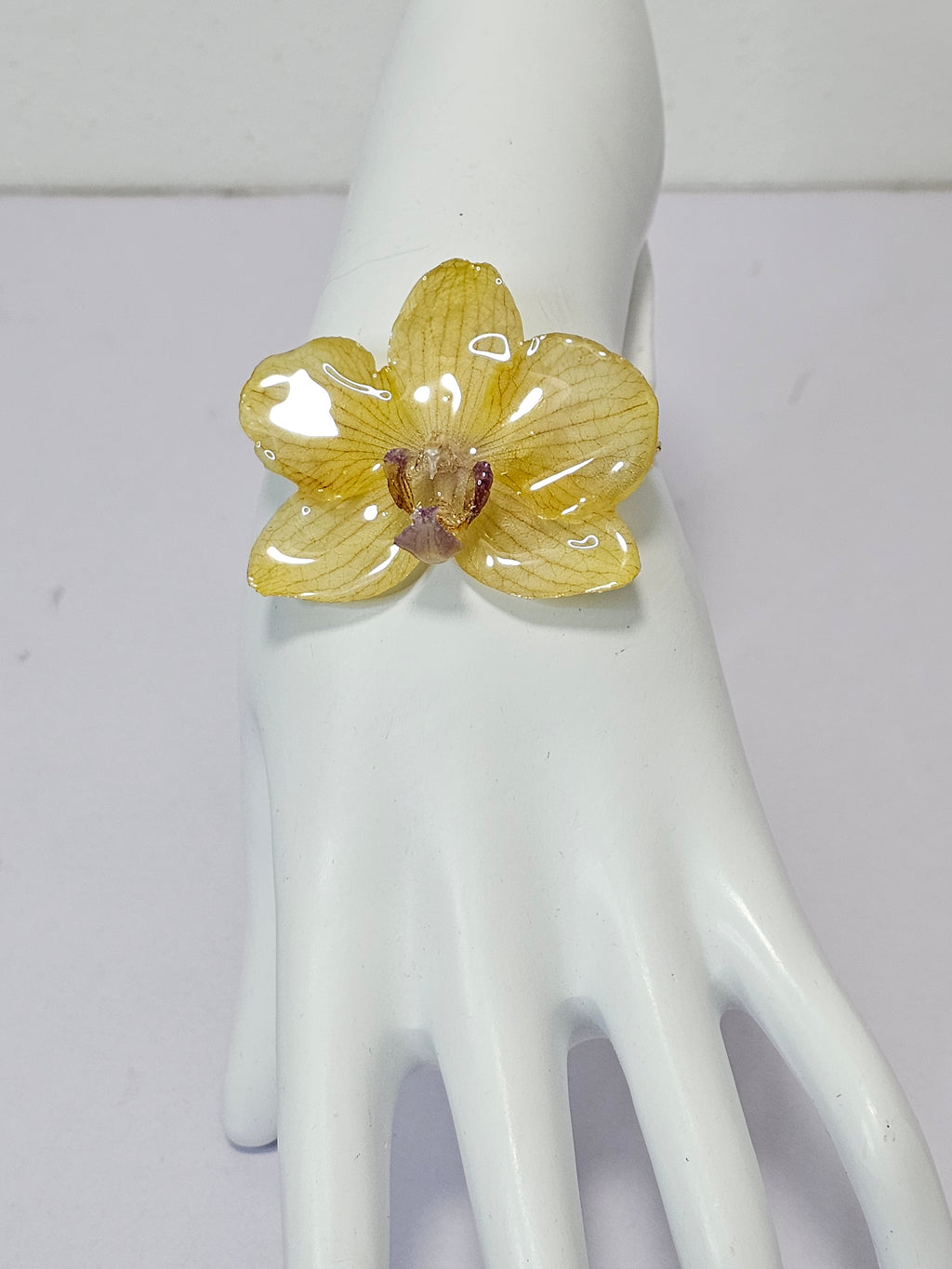 Pulsera de Mini Orquídea Amarilla artesanal con flor natural preservada; material: acero inoxidable