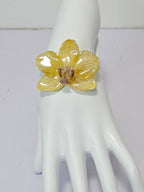 Pulsera de Mini Orquídea Amarilla artesanal con flor natural preservada; material: acero inoxidable