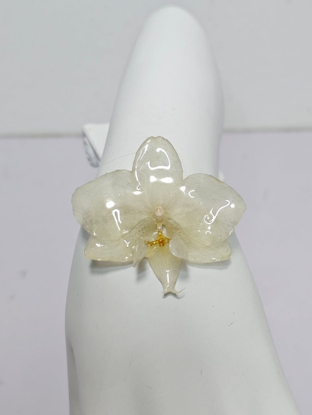 Pulsera de Mini Orquídea Blanca artesanal con flor natural preservada; material: acero inoxidable