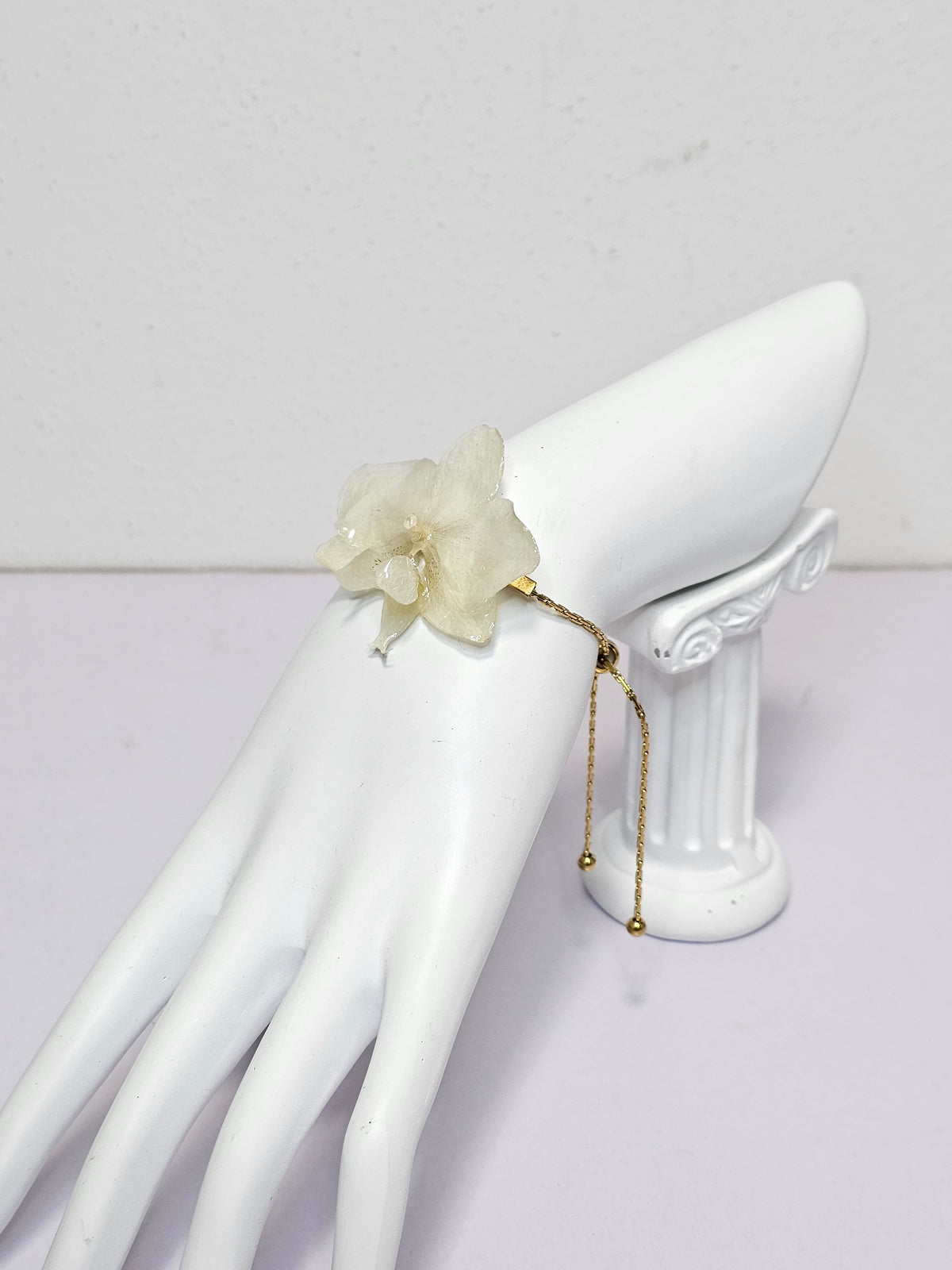 Pulsera de Mini Orquídea Blanca artesanal con flor natural preservada; material: acero inoxidable, vista 3