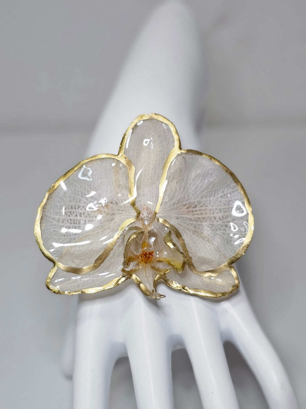 Pulsera de Orquídea Blanca Dorada de ISAMOR con flor natural preservada y encapsulada