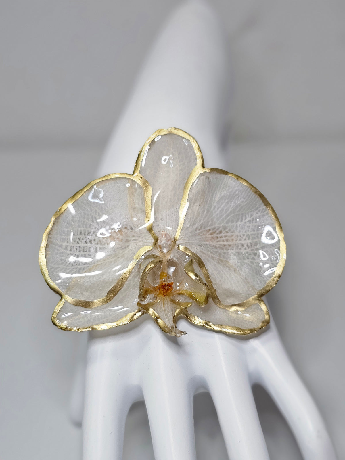 Pulsera de Orquídea Blanca Dorada de ISAMOR con flor natural preservada y encapsulada