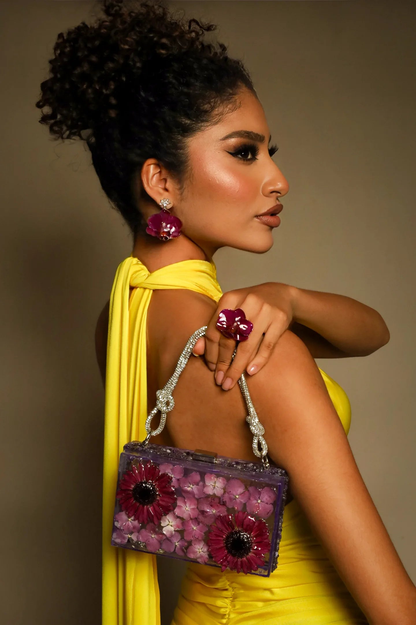 Modelo luciendo aretes, anillo y bolso floral de ISAMOR