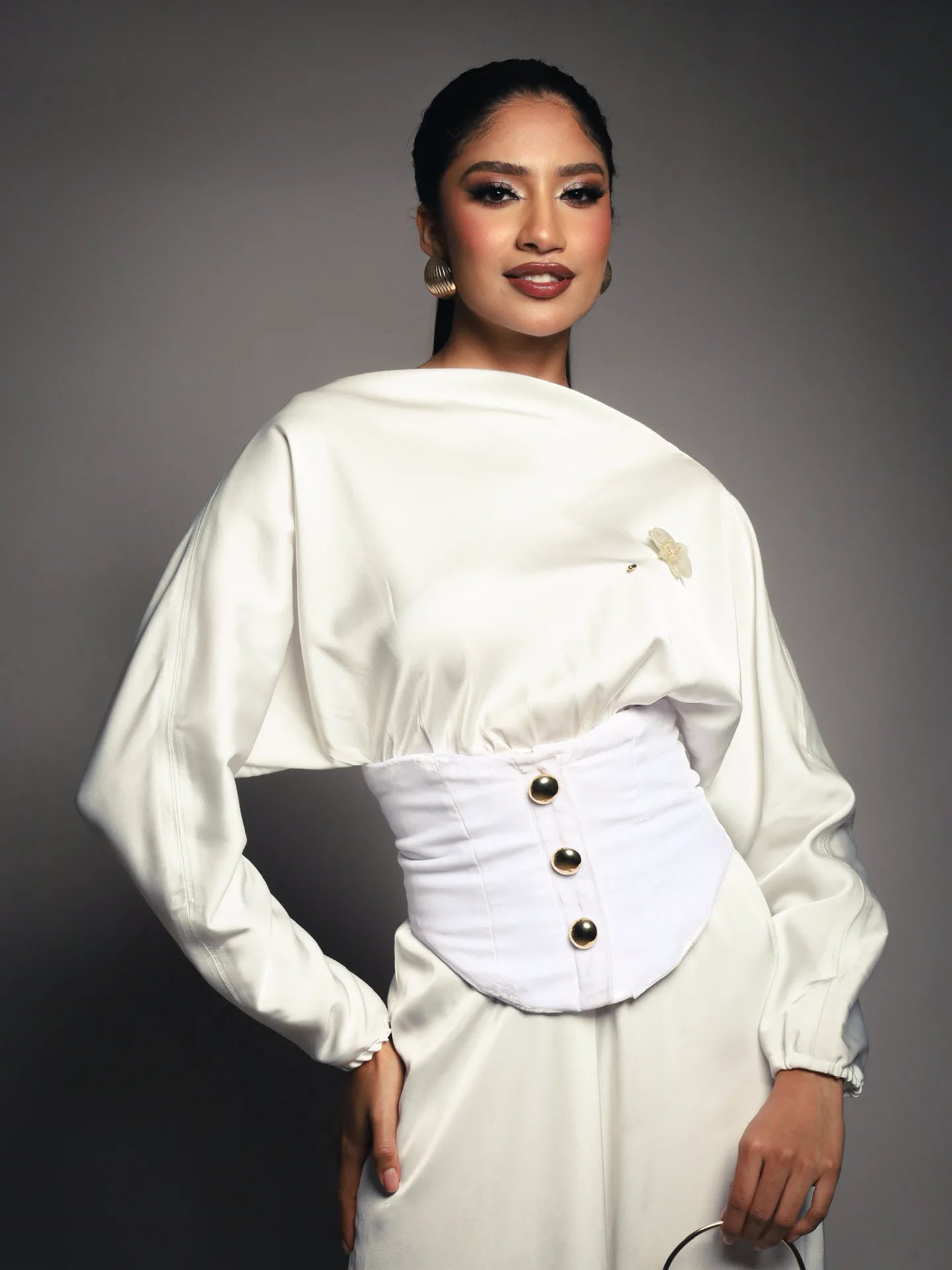 Modelo con atuendo blanco luciendo un broche floral de ISAMOR